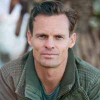 Close-up portrait of a man wearing a casual jacket outdoors.